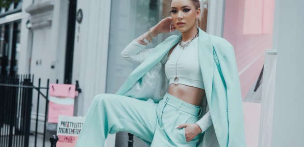 A stylish, fashion-forward young woman posing confidently on a chic London street, wearing a trendy pastel outfit from PrettyLittleThing UK
